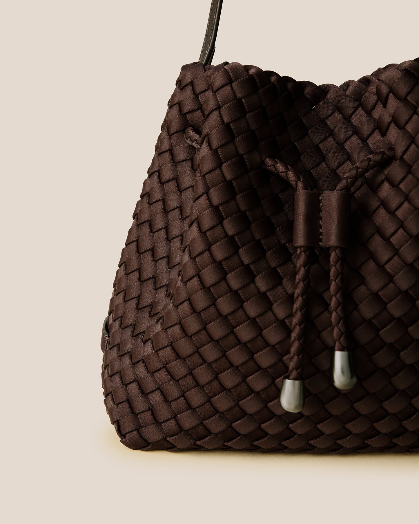 A rich chocolate-toned crossbody bucket bag featuring handwoven neoprene texture, drawstring closure, and adjustable leather strap—showcasing artisanal craftsmanship and tactile elegance by Valnera Vista-2