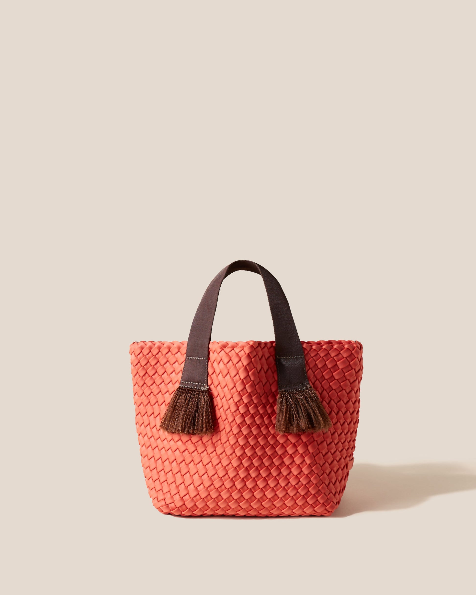 A woven texture crossbody bag with a structured flap and slender strap—evoking coastal charm with tactile appeal and refined artistry
