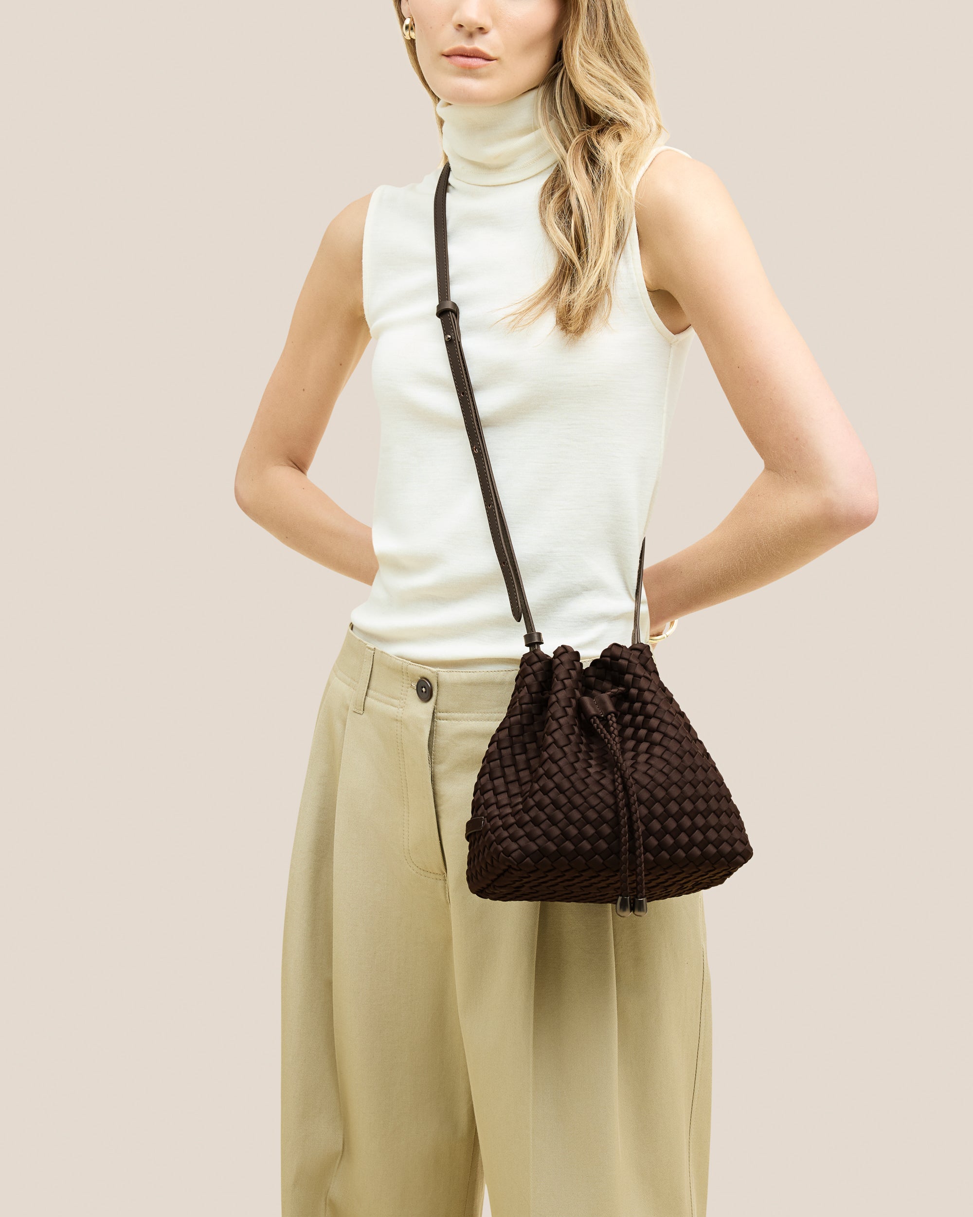 A rich chocolate-toned crossbody bucket bag featuring handwoven neoprene texture, drawstring closure, and adjustable leather strap—showcasing artisanal craftsmanship and tactile elegance by Valnera Vista-5